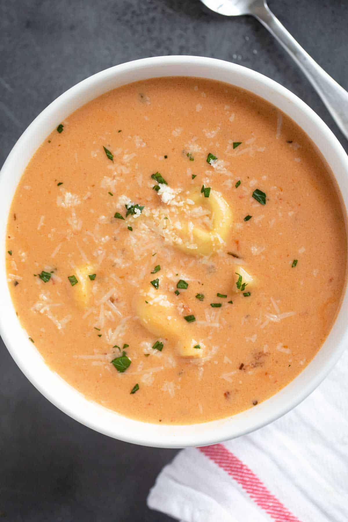 Bowl of Creamy Tortellini Soup topped with parmesan cheese.