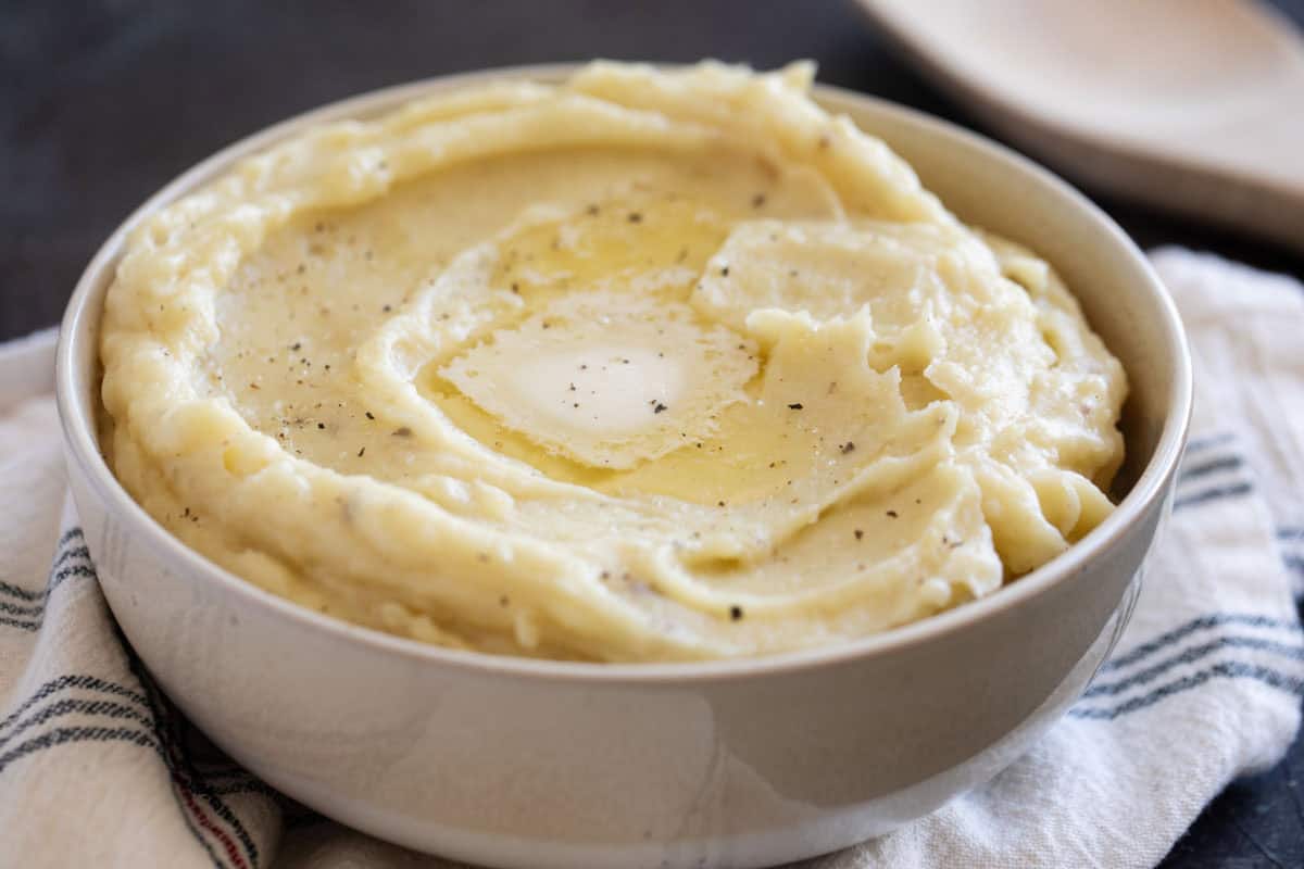 Bowl filled with mashed potatoes made in the crockpot.