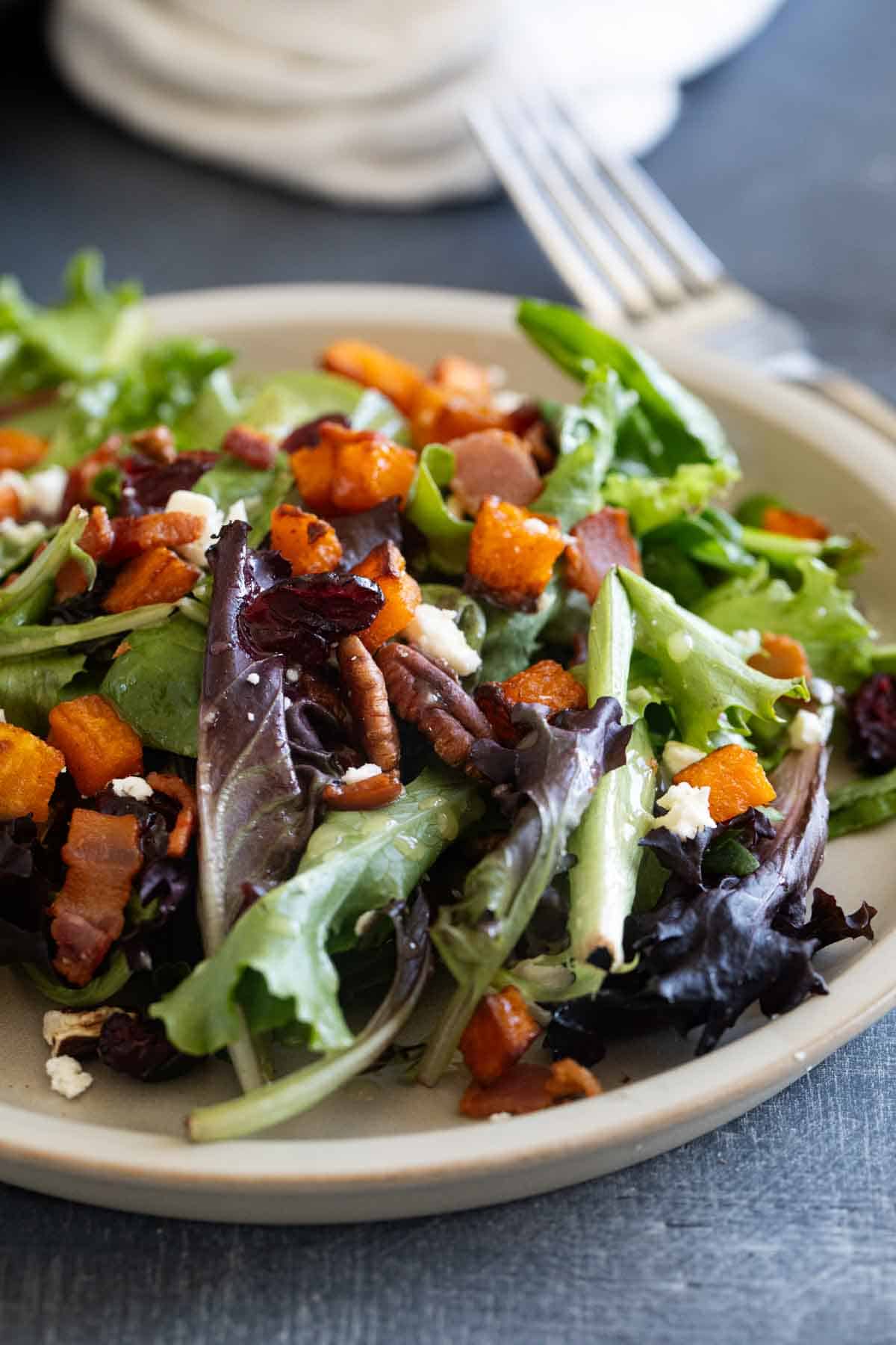 Fall Harvest Salad on a dinner plate with a fork.