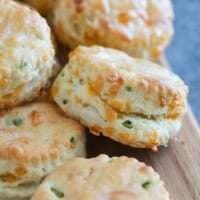 Jalapeño Cheddar Biscuits stacked on a board.