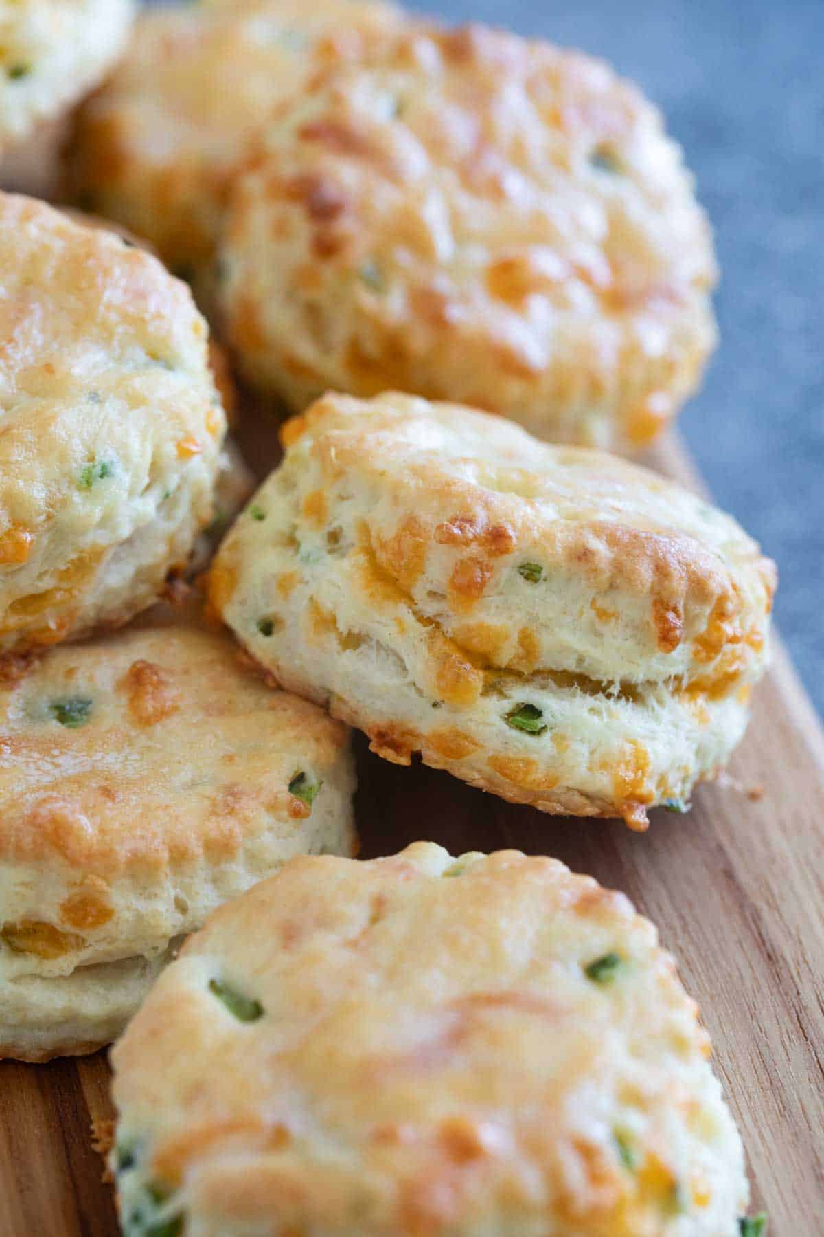 Jalapeño Cheddar Biscuits stacked on a board.