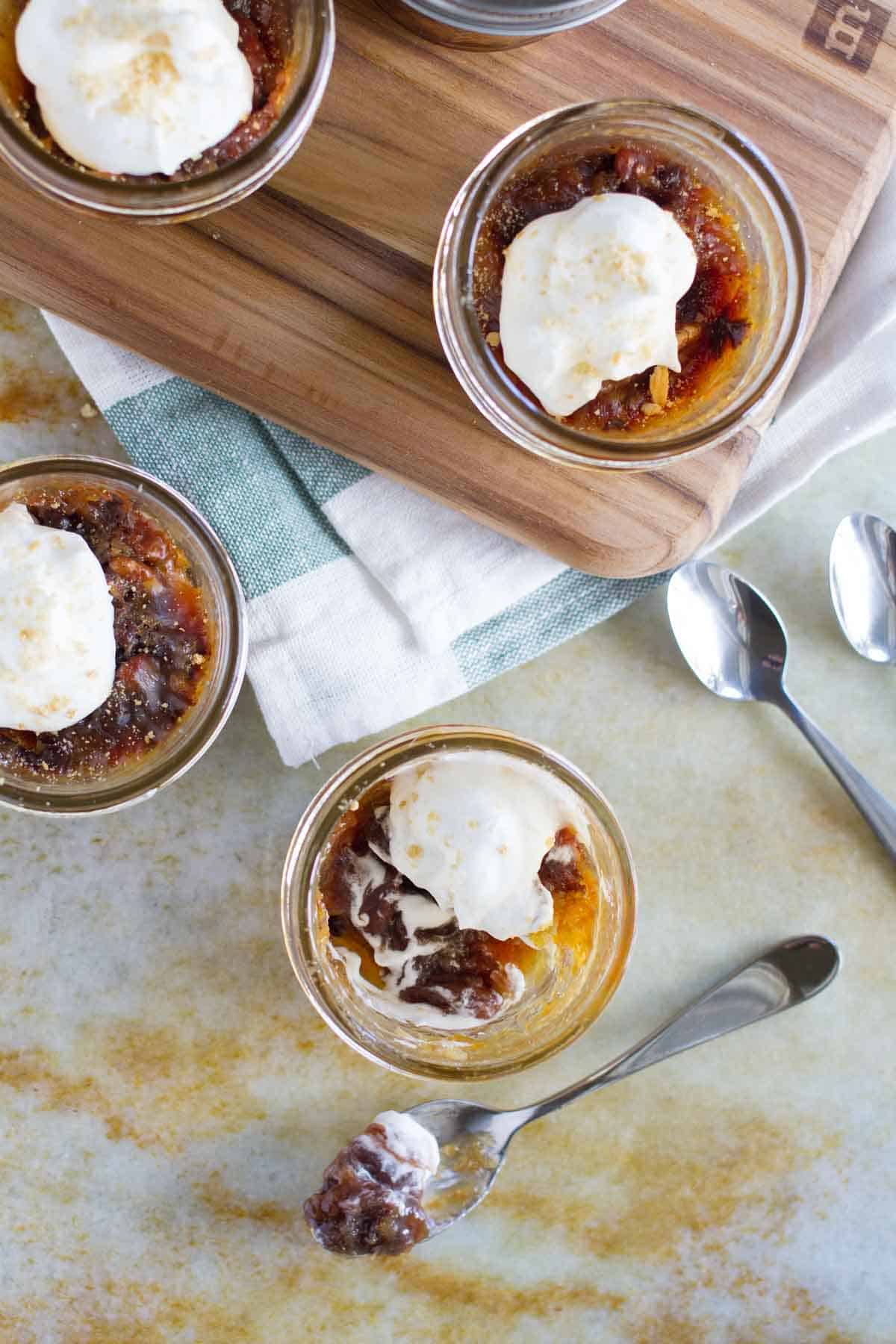 Mini Chocolate Pecan Pie in a Jar topped with whipped cream, with a bite taken from one.