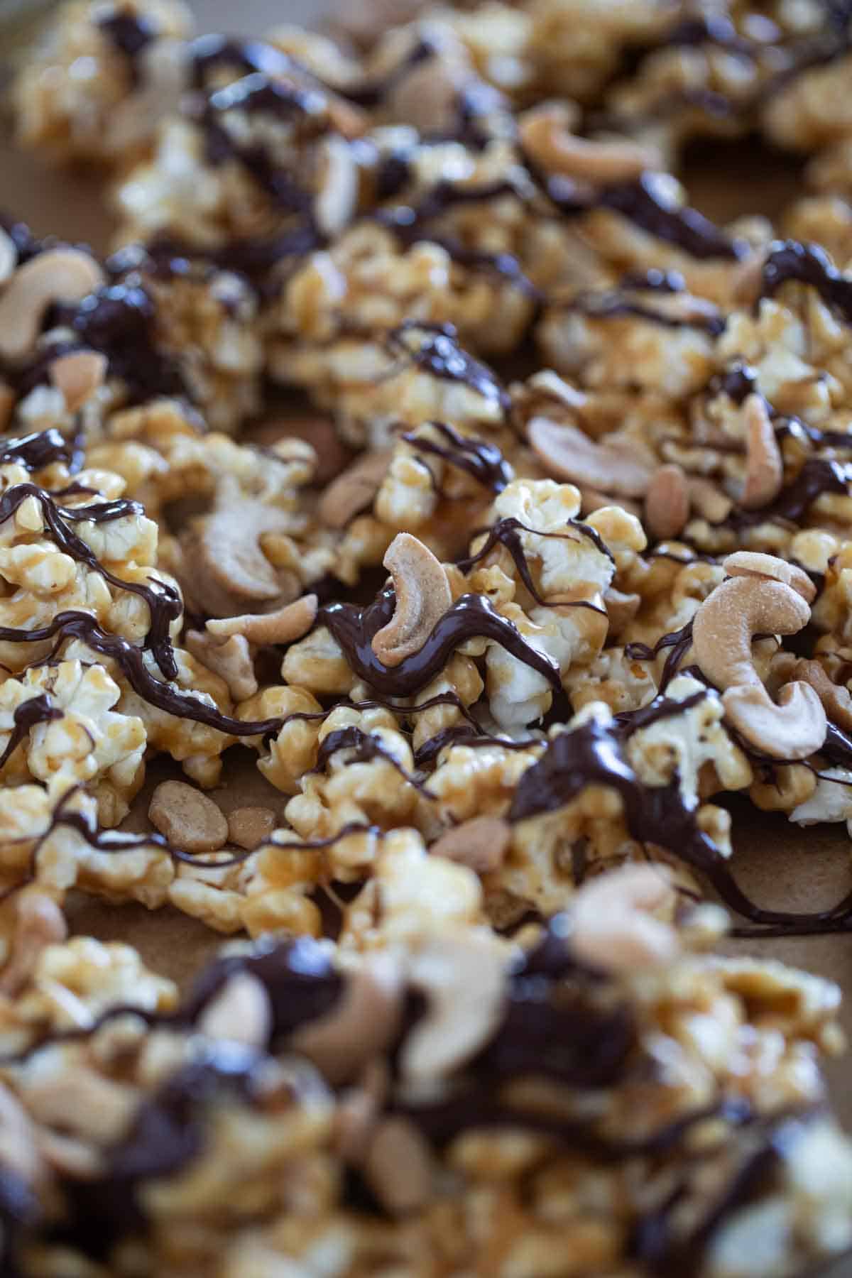 Peanut butter popcorn drizzled with chocolate and sprinkled with cashews.