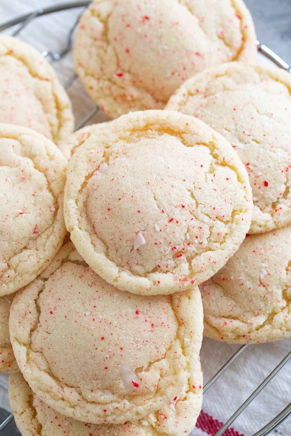 Peppermint snickerdoodles stacked on a cooling rack.