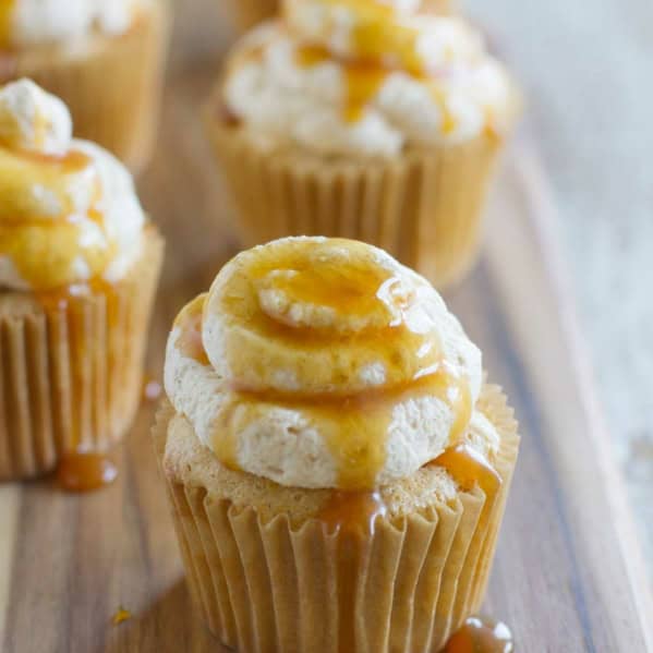 Pumpkin Angel Food Cupcakes topped with spiced whipped cream and caramel sauce.