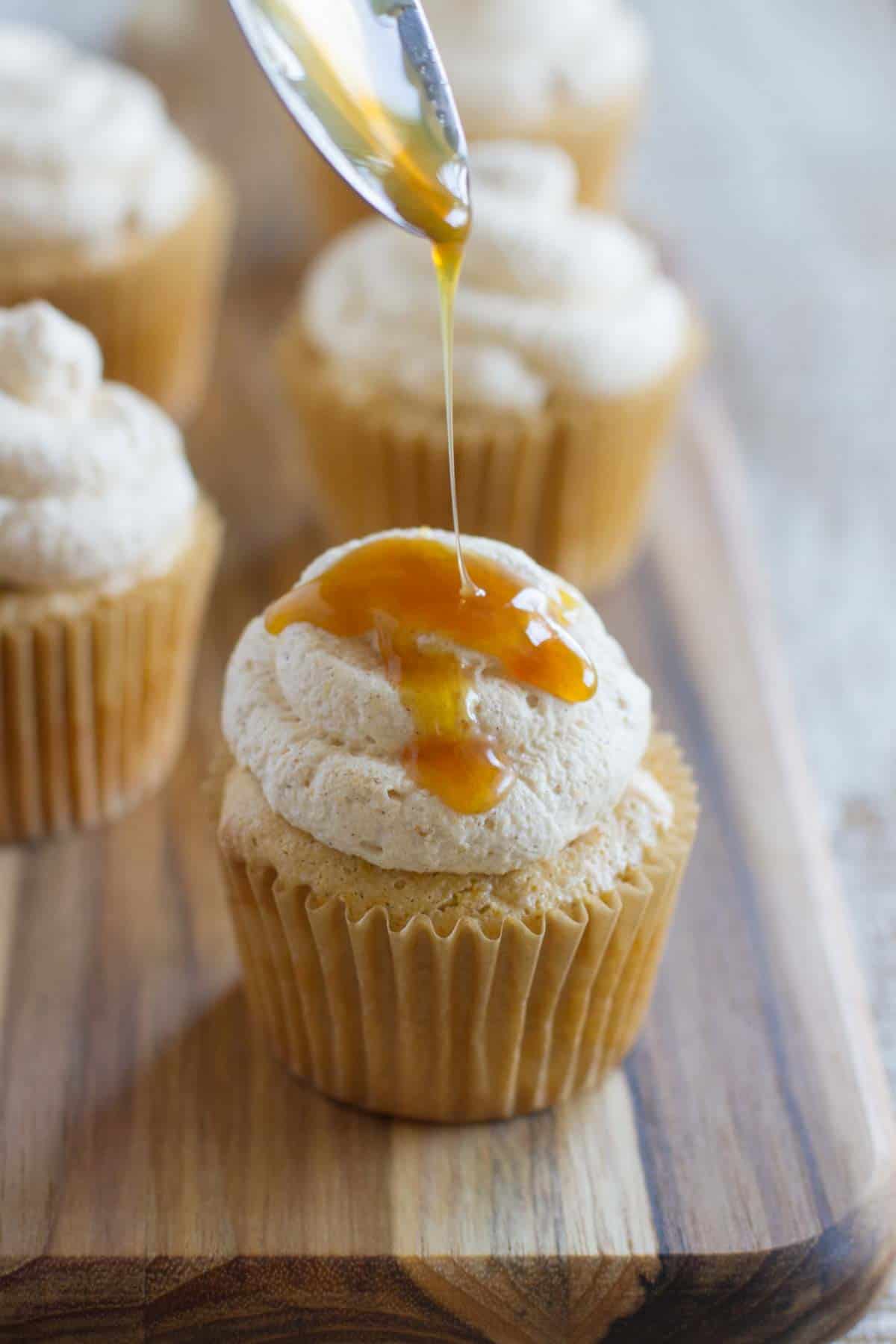 Drizzling caramel sauce over a pumpkin angel food cupcake.