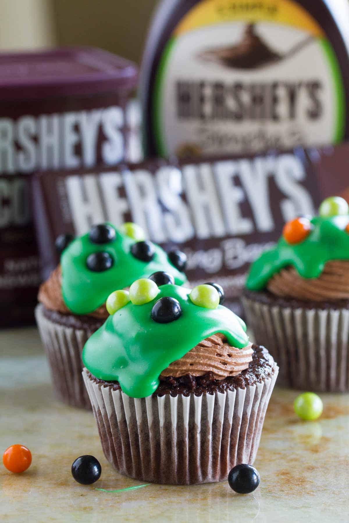 Ultimate Chocolate Cupcakes decorated for Halloween with green ganache and candy.