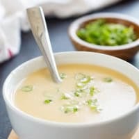 Bowl of Cheddar Cheese Soup topped with green onions.