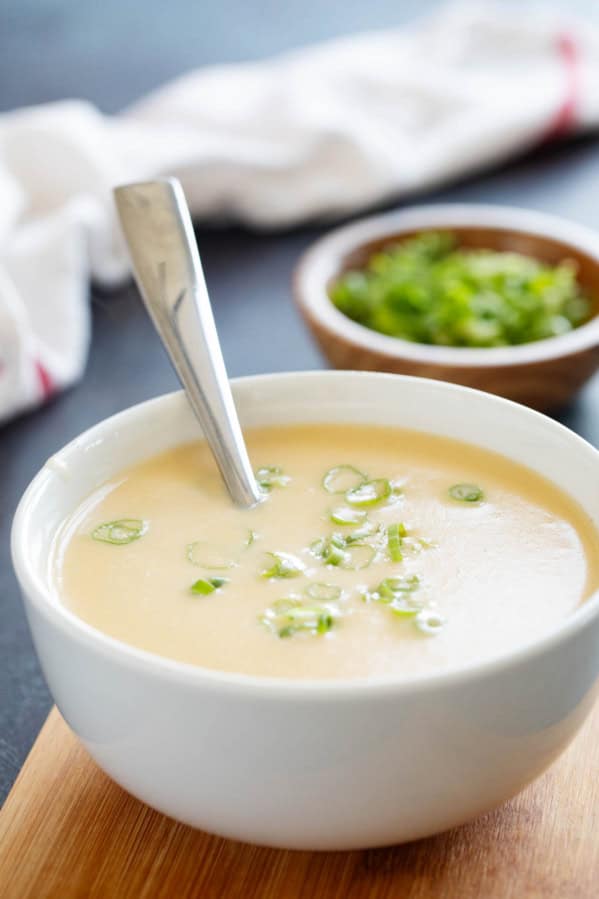 Bowl of Cheddar Cheese Soup topped with green onions.