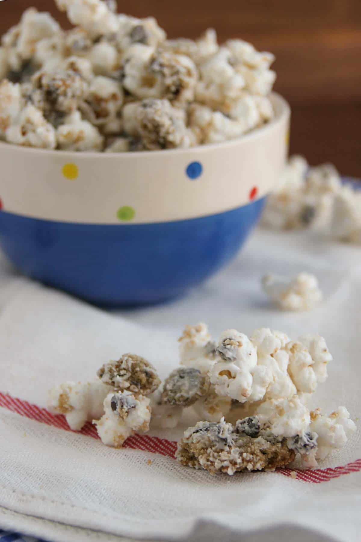 Chocolate Chip Cookie Popcorn on a towel by a bowl filled with popcorn.