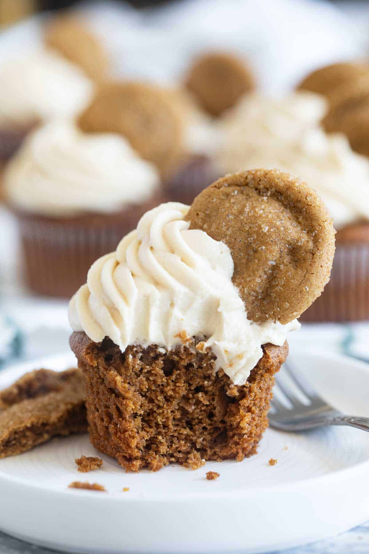 Gingerbread cupcake with a bite taken from it to show interior texture.