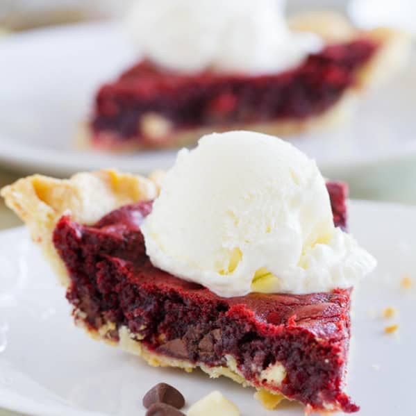 Slice of Red Velvet Cookie Pie topped with a scoop of ice cream.