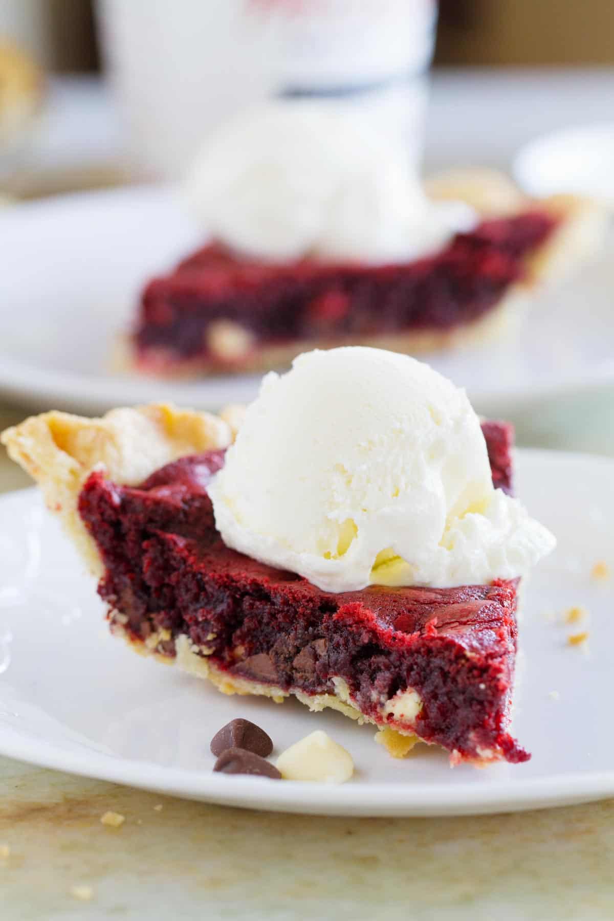 Slice of Red Velvet Cookie Pie topped with a scoop of ice cream.