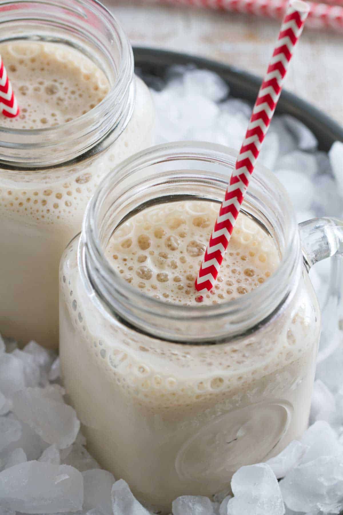 Two root beer float smoothies in ice.