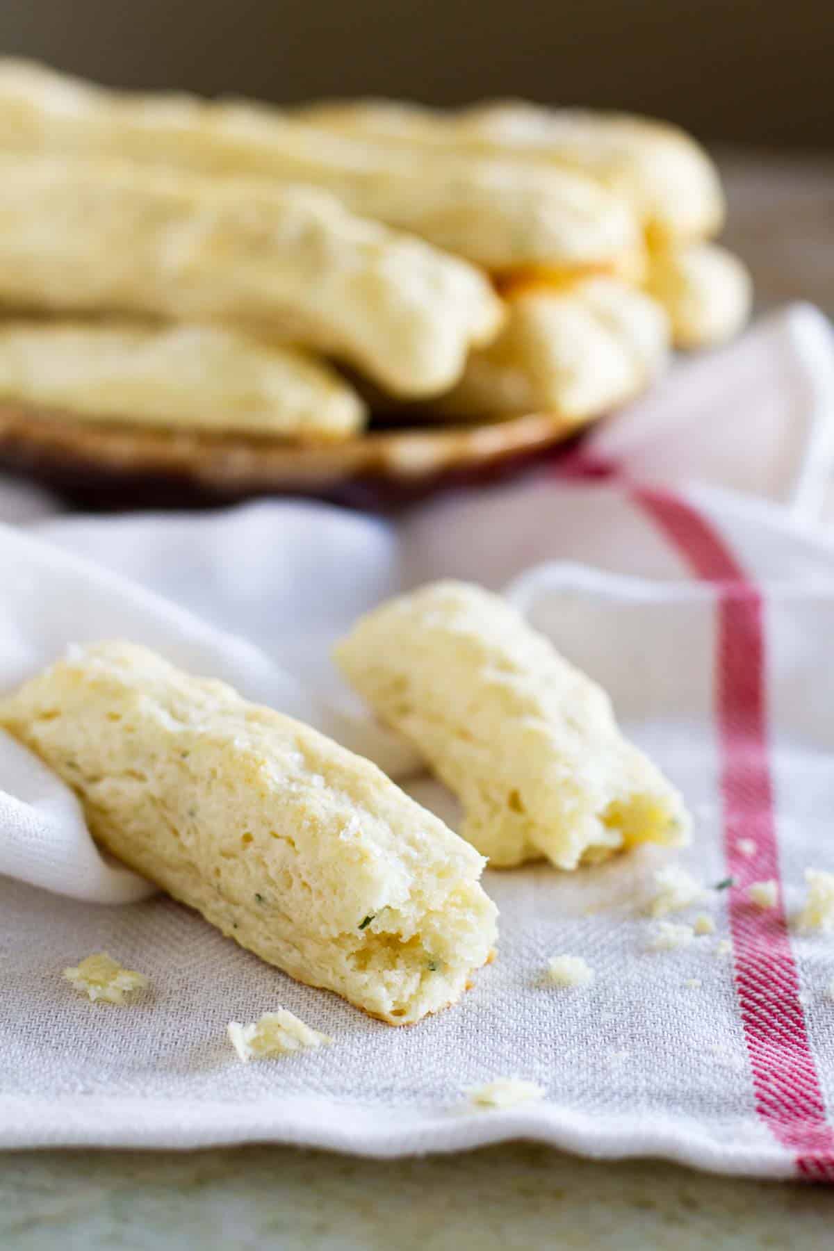 Sour cream breadstick torn in half on a towel.