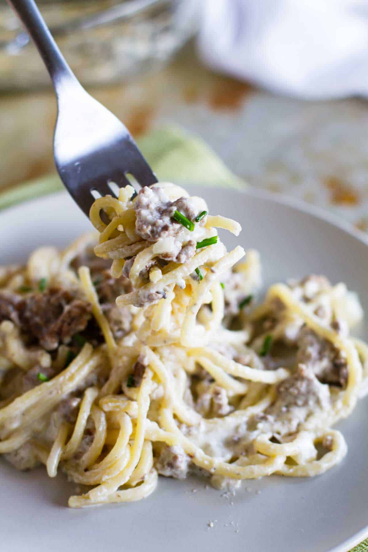 Fork full of beef and blue cheese baked spaghetti.