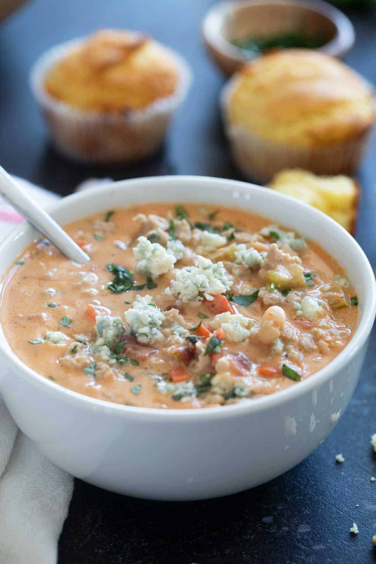 Bowl of buffalo chicken chili topped with blue cheese and cilantro.