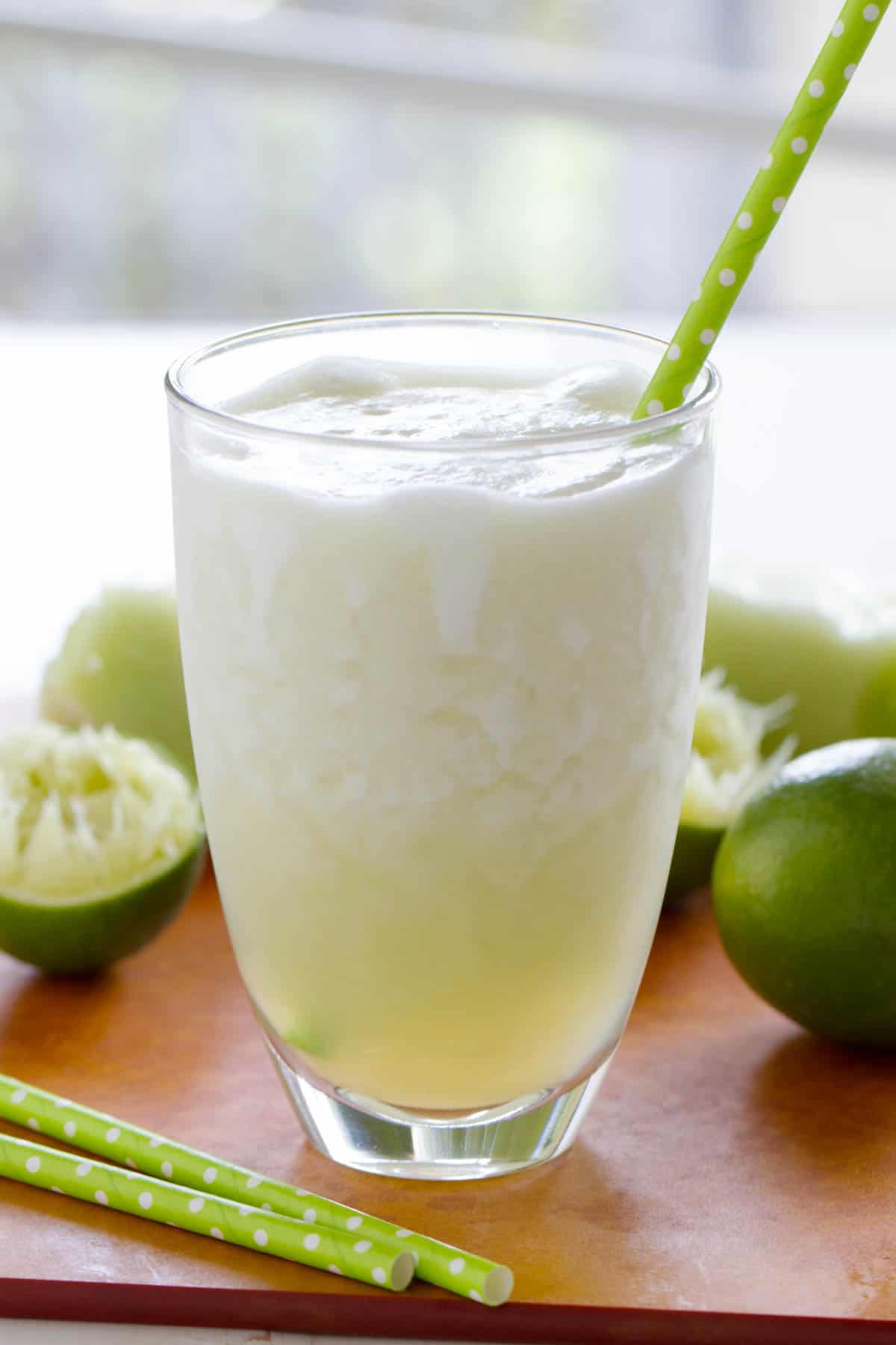 Honeydew Lime Smoothie with limes in the background.