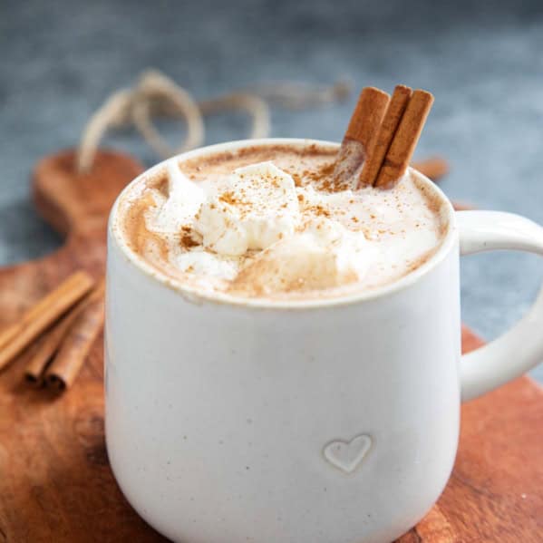 Mug of Mexican Hot Chocolate, topped with whipped cream and sprinkled with cinnamon.