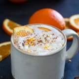 Orange Hot Chocolate topped with whipped cream, chocolate shavings, and orange zest.