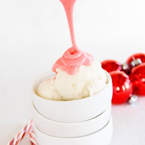 Drizzling peppermint marshmallow sauce over a scoop of vanilla ice cream.