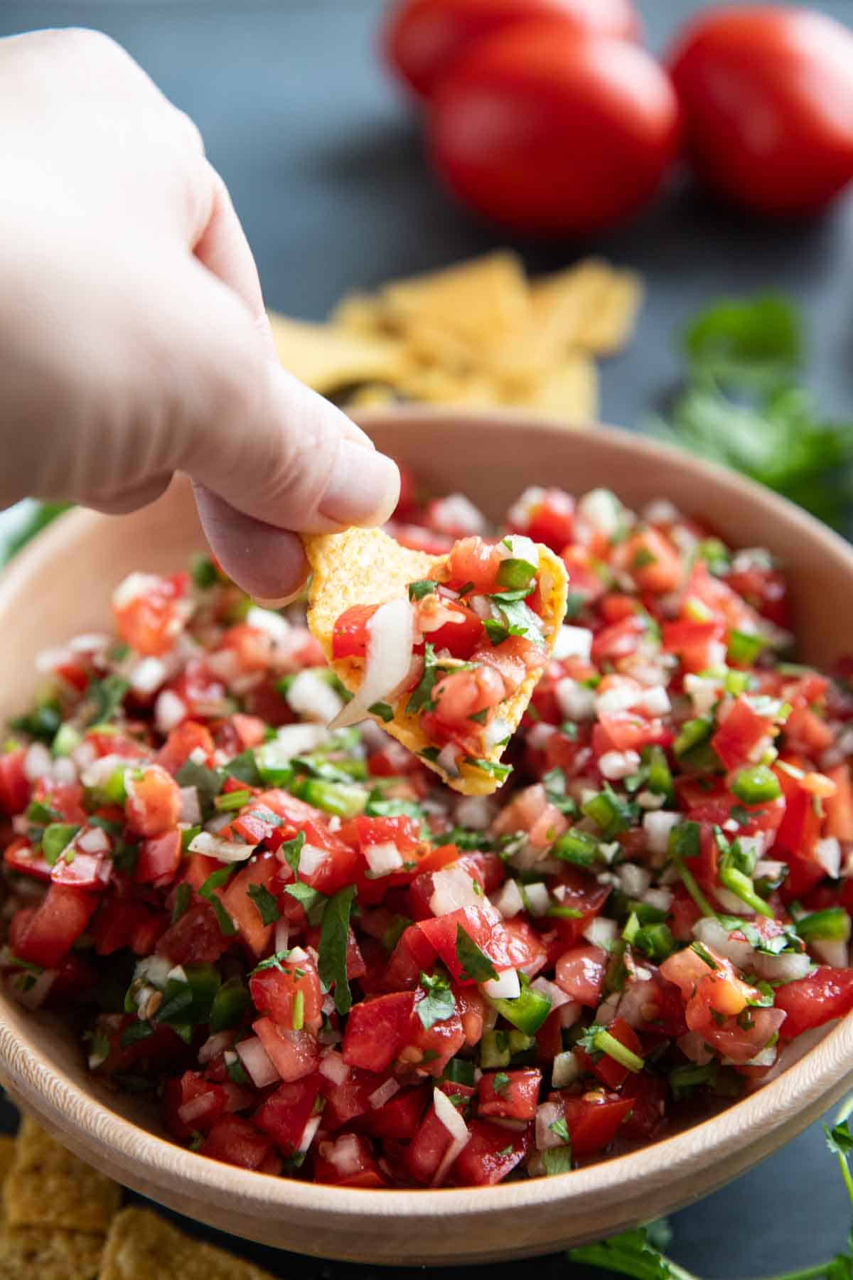 Dipping a chip into pico de Gallo.