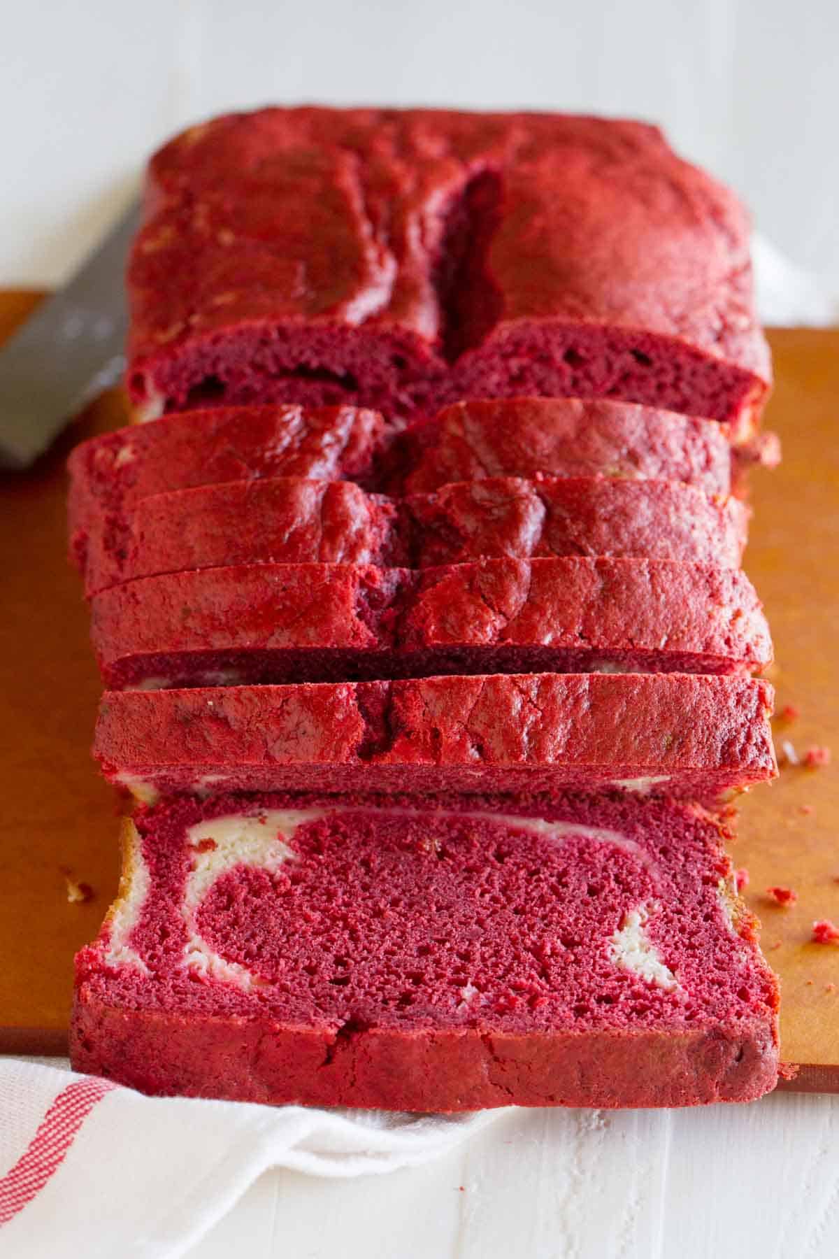 Sliced loaf of Red Velvet Quick Bread with Cream Cheese Filling - showing the cut side of one slice.