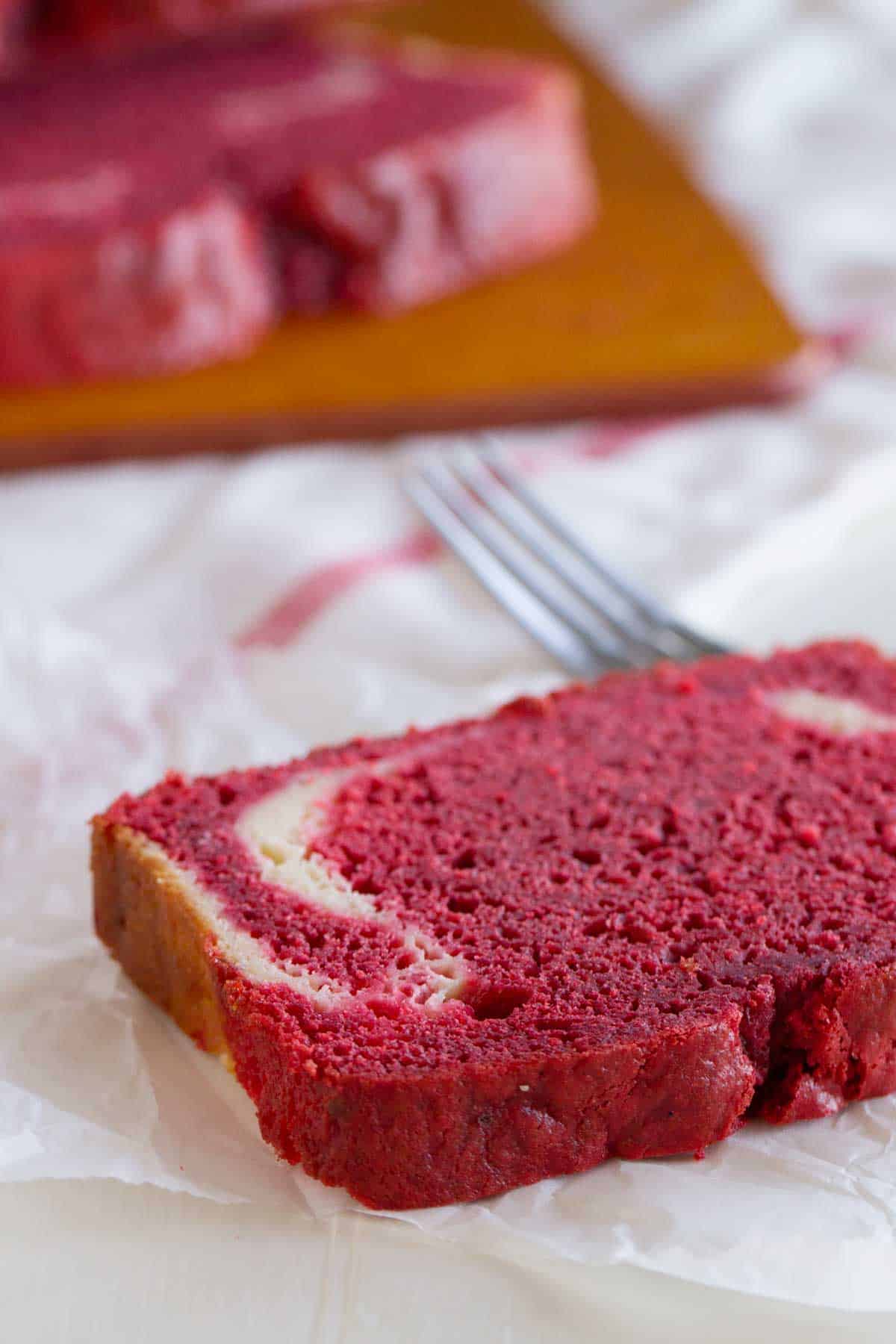 Slice of red velvet quick bread with cream cheese filling.