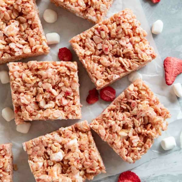 Strawberry Rice Krispie Treats cut into bars, with freeze dried strawberries and mini marshmallows.