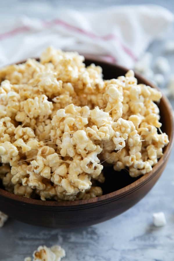 Wooden bowl filled with caramel marshmallow popcorn.