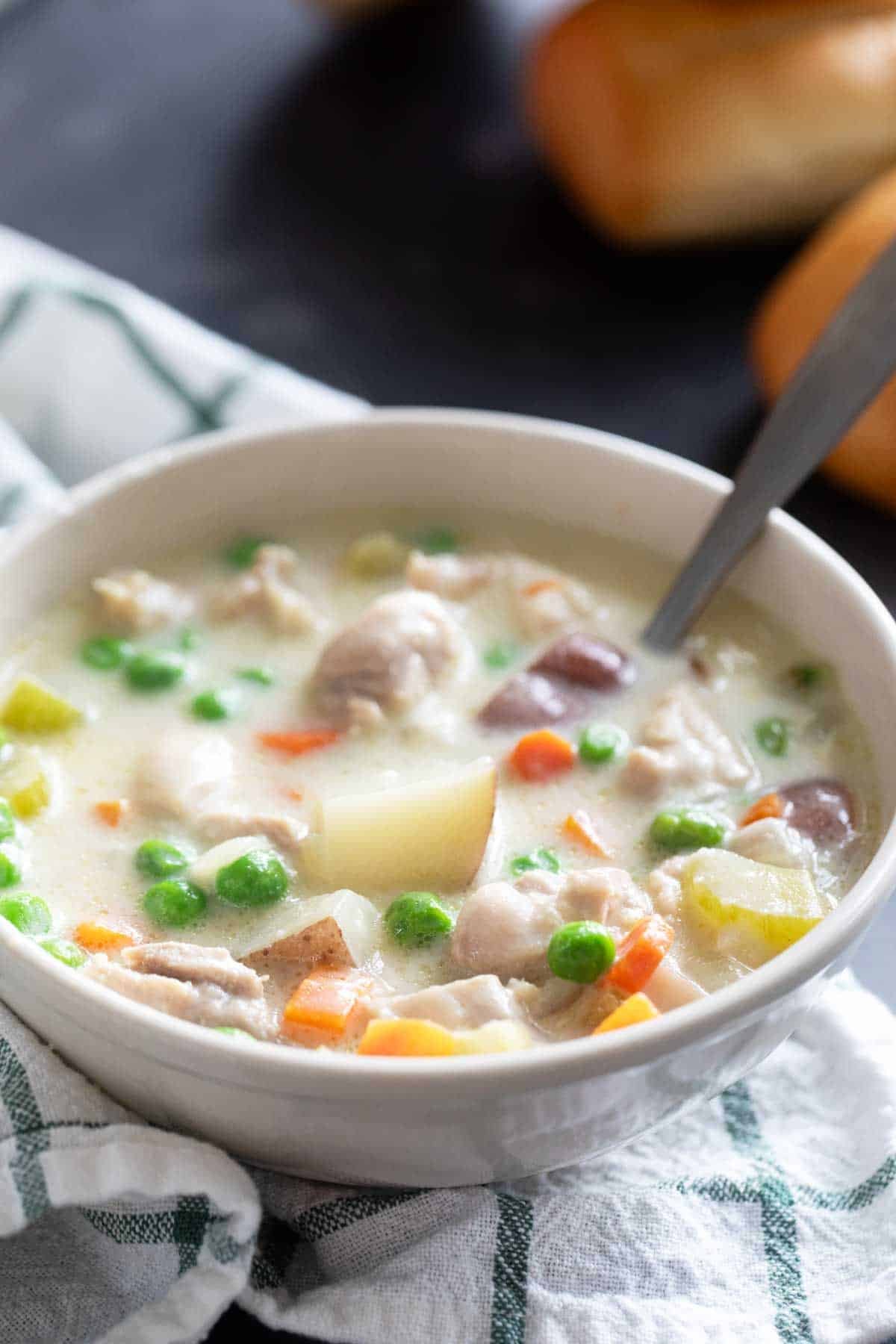 Bowl of chicken stew with a spoon.