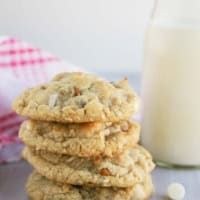 Four Cinnamon, White Chocolate, and Coconut Oatmeal Cookies stacked on top of each other.