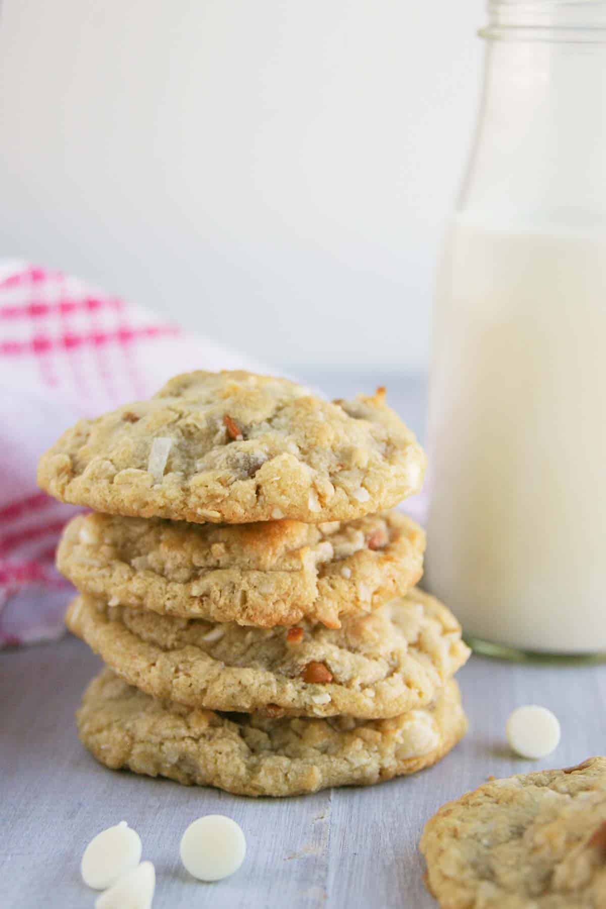 Four Cinnamon, White Chocolate, and Coconut Oatmeal Cookies stacked on top of each other.