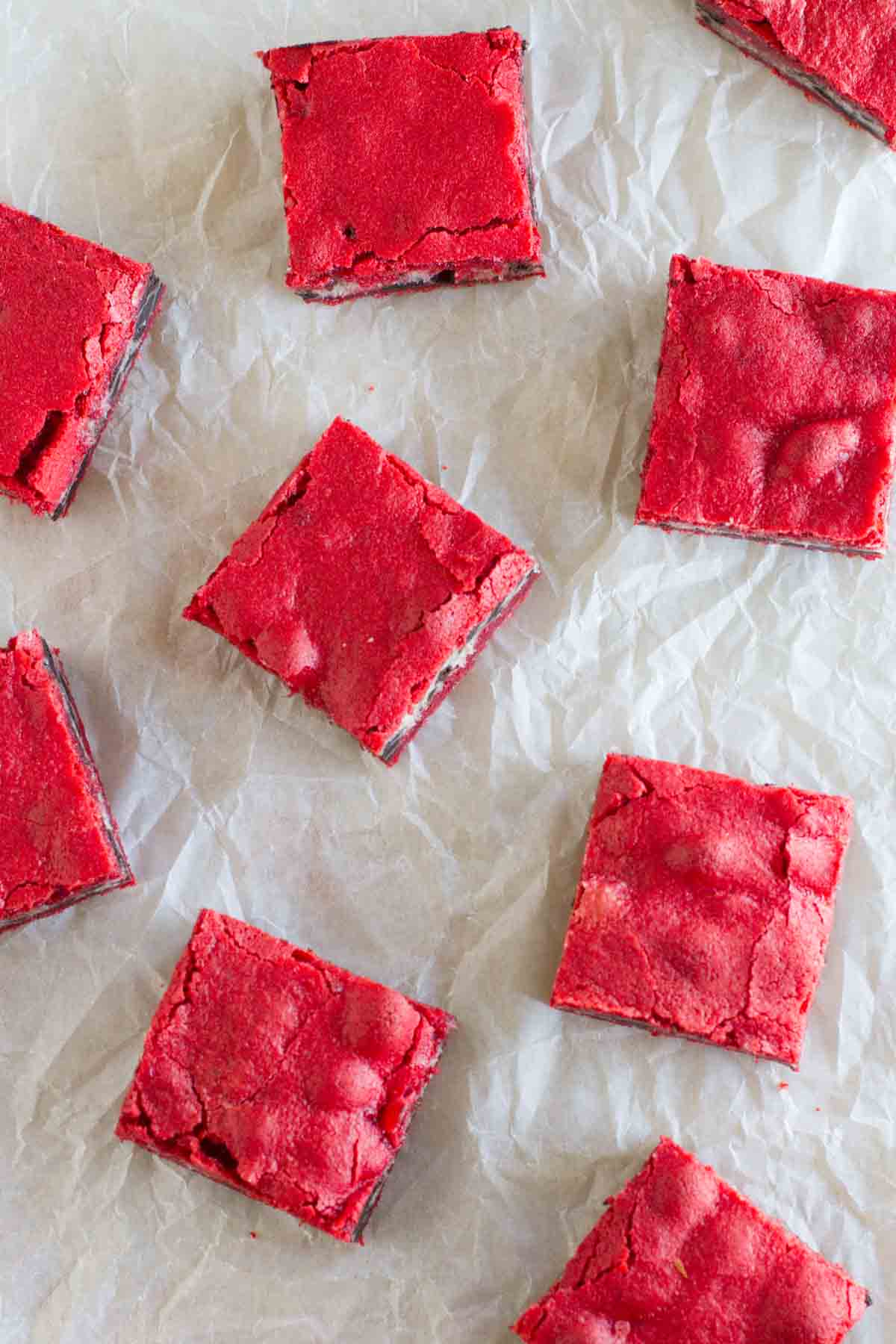 Oreo Cream Cheese Stuffed Red Velvet Brownies on parchment paper.