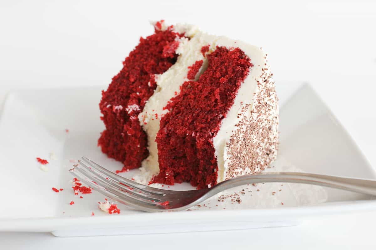 Slice of red velvet cheesecake cake with bites taken from it.