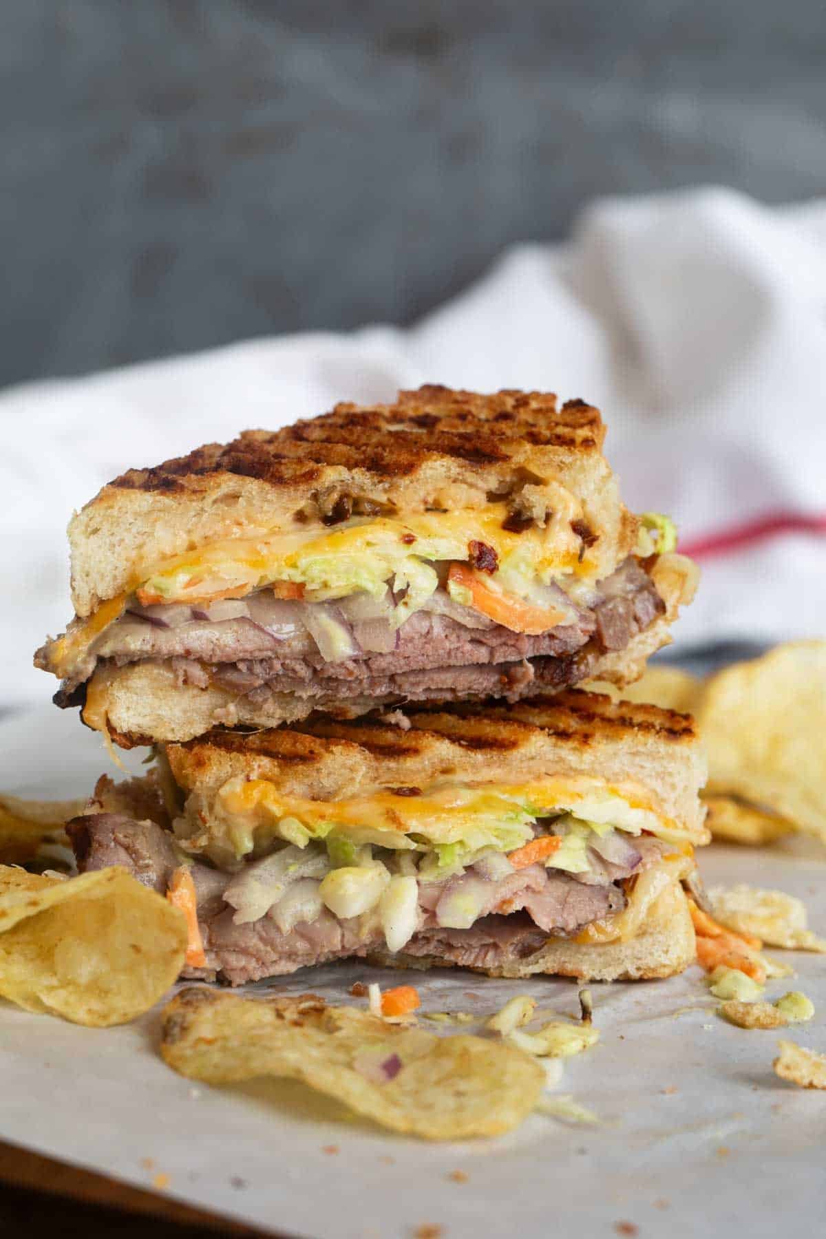 Roast beef panini cut in half and stacked on top of each other.