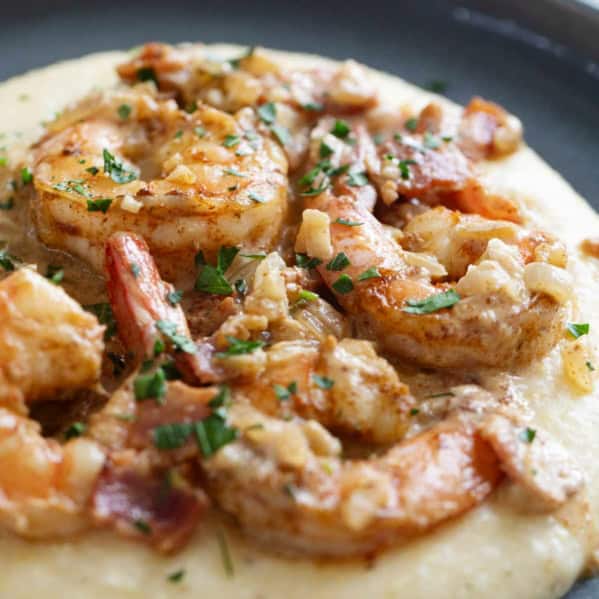 Shrimp and grits with bacon and parsley.