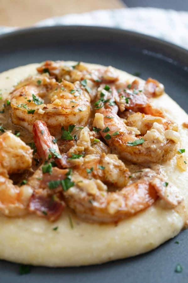 Shrimp and grits with bacon and parsley.