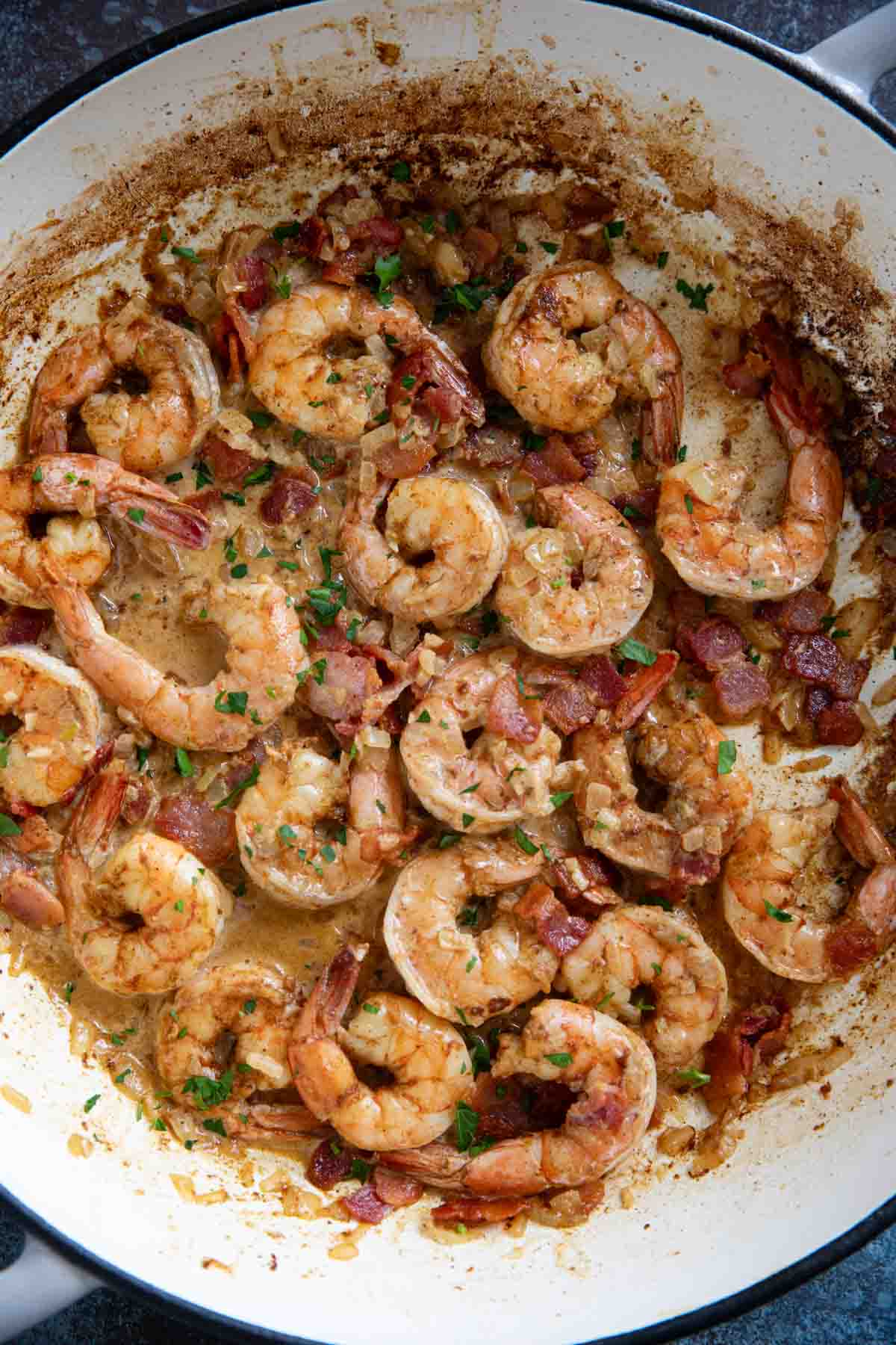 Cajun shrimp with bacon in a large skillet.