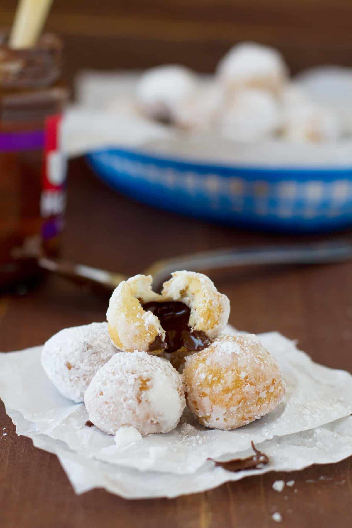 Chocolate Hazelnut Stuffed Donut Holes stacked on top of each other with one broken open.