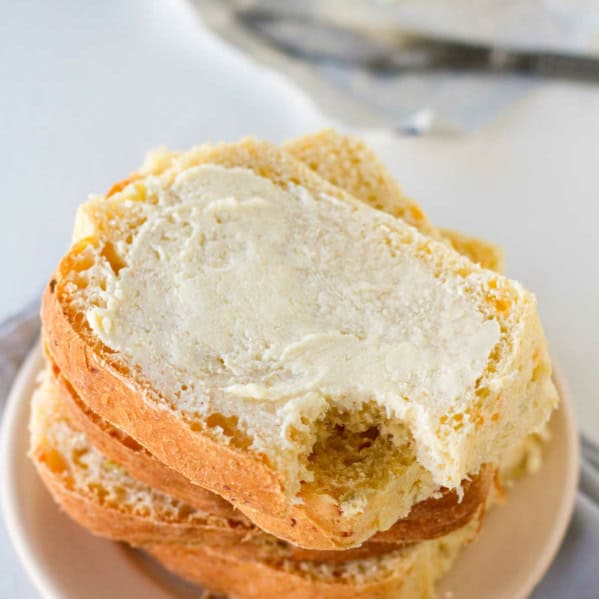 Slices of green Chile cheddar bread stacked on top of each other, with a bite taken from one piece.