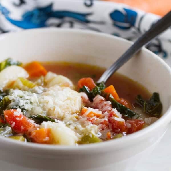 Bowl of Minestrone with Gnocchi with a spoon in it.