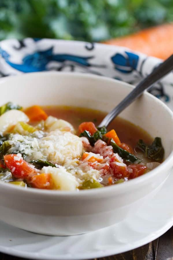 Bowl of Minestrone with Gnocchi with a spoon in it.